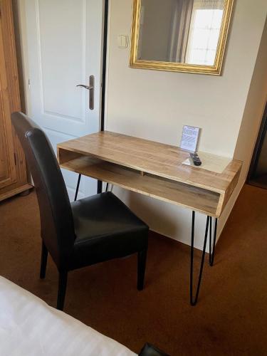a desk in a room with a chair and a mirror at Penzion Bystrica in Považská Bystrica