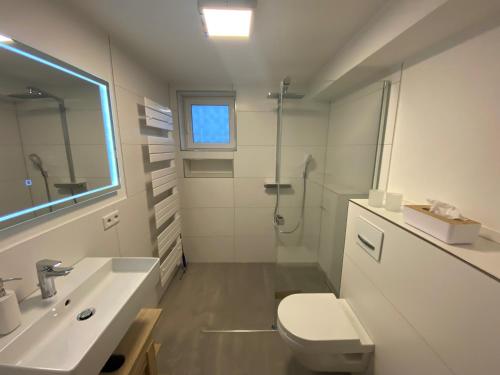 uma casa de banho branca com um lavatório e um WC em Ferienhaus zur Glocke em Winterberg