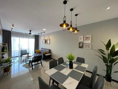 a dining room and living room with a table and chairs at Ipoh Waterpark Manhattan Premium Suites by IWH Suites in Ipoh