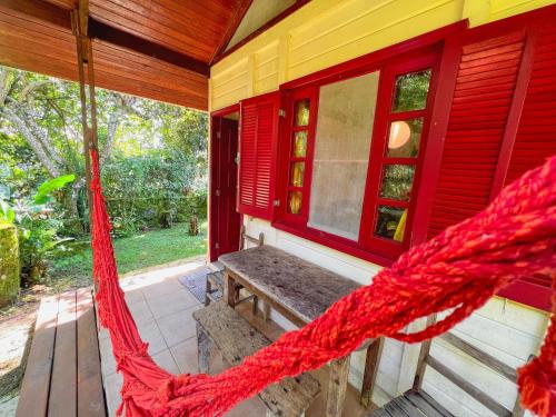 a porch with a hammock on a house at Condomínio Aldeia in Abraão