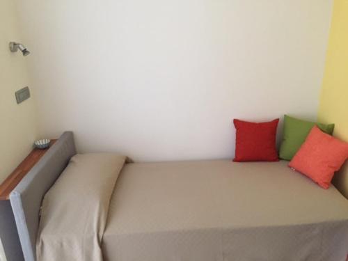 a bed in a room with three pillows on it at My Home in Pero