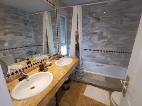 a bathroom with two sinks and a tub at Luxury Paradise Beach Villa in Vera