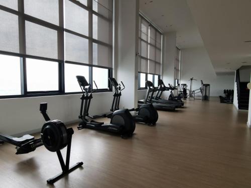 a gym with a row of treadmills and exercise bikes at Harmonee Homes - Mode Chill at The Hub SS2, PJ in Petaling Jaya