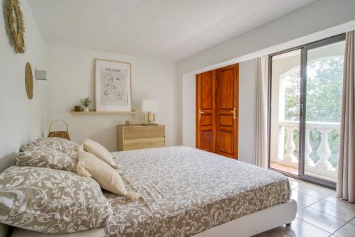 a white bedroom with a bed and a window at CHARMANT 2 PIECES DANS VILLA INDIVIDUELLE TERRASSES JARDIN in Carros