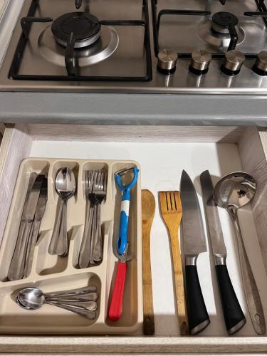 a drawer filled with kitchen utensils in a sink at Solo apartments in Ureki