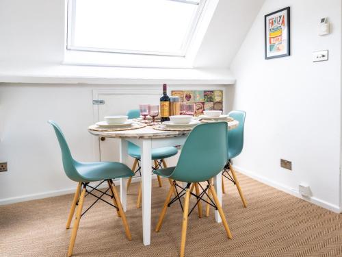 a dining room with a table and four chairs at Pass the Keys Tranquil cosy apartment in centre of Avening in Avening