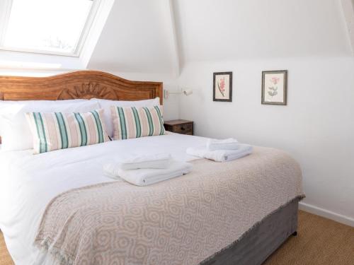 a bedroom with a bed with two towels on it at Pass the Keys Tranquil cosy apartment in centre of Avening in Avening