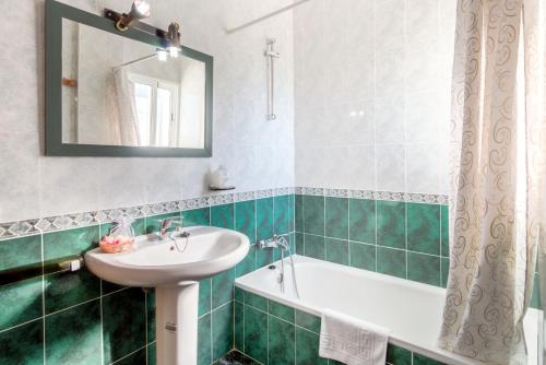 a bathroom with a sink and a tub and a mirror at Conjunto Rural Las Rosas in Frigiliana