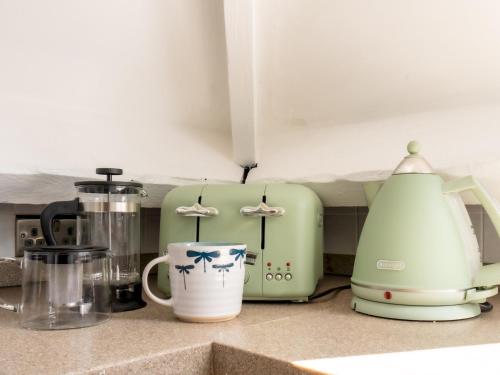 a kitchen counter with a toaster and a coffee maker at Pass the Keys Tranquil cosy apartment in centre of Avening in Avening