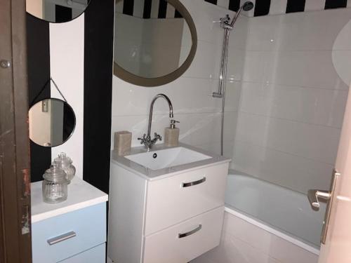La salle de bains blanche est pourvue d'un lavabo et d'une douche. dans l'établissement Vue imprenable sur mer, à Saint Pierre La Mer