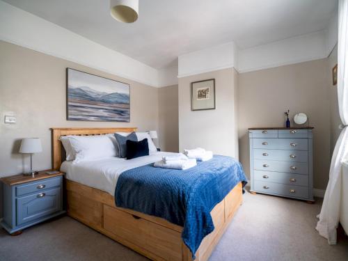 1 dormitorio con 1 cama grande con manta azul en Pass the Keys Bath Road Retreat 2 bedrooms with garden, en Cheltenham