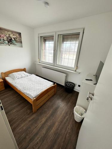 1 dormitorio con 1 cama y 2 ventanas en Zimmervermietung Altes Zollhaus en Obernkirchen
