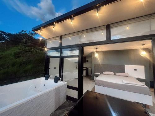 a bedroom and a bathtub and a bed and a bath tub at Cabaña en Sopetran con jacuzzi in Sopetran