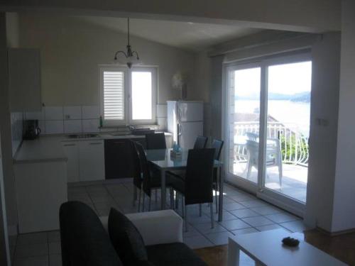 a kitchen and dining room with a table and chairs at Villa Curkovic in Ražanj
