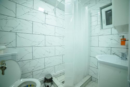 a white bathroom with a toilet and a sink at Cabana de Sub Deal Arieșeni in Arieşeni