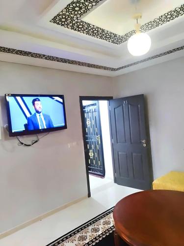 een kamer met een tv aan een muur met een deur bij Wohnung in martil in Martil