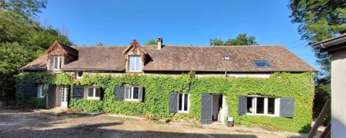 une maison couverte de lierre vert avec un toit dans l'établissement 2 Maisons à 45 minutes de Paris, à Ouerre