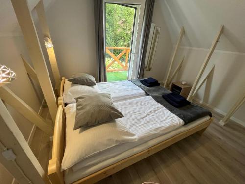 a bed with white sheets and pillows in a room at U Gruszków - domek pod Chojnikiem in Jelenia Góra