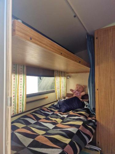 - un ours en peluche assis sur un lit dans une chambre dans l'établissement Cozy Caravan With House Access!, à Luleå
