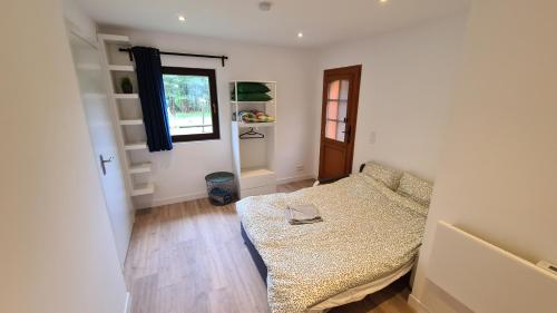 a small bedroom with a bed and a window at Les Bossons Studio in Chamonix