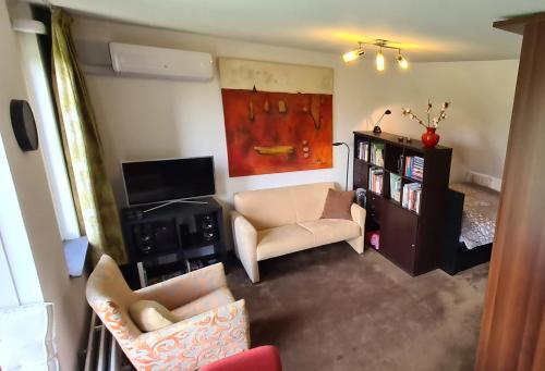 a living room with a couch and a tv at StudioRandijk in Nieuwegein