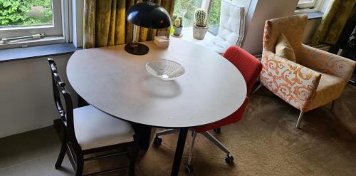 a white table with two chairs and a lamp at StudioRandijk in Nieuwegein