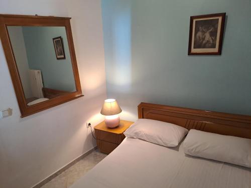 a bedroom with a bed with a mirror and a lamp at NAFPAKTOS old town in Nafpaktos