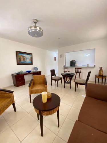 un soggiorno con divano, tavoli e sedie di Apartamentos LC cerca de la playa a La Romana