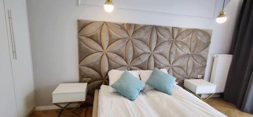 a bedroom with a bed with two blue pillows at Apartamenty Baltic Sea Westin House 404 in Kołobrzeg