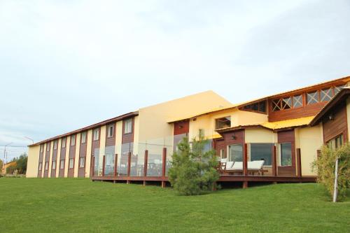 a large building with a lawn in front of it at Hotel Picos Del Sur in El Calafate