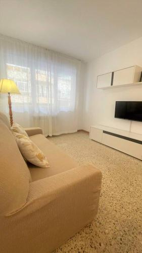 een woonkamer met een bank en een flatscreen-tv bij Sueños de Mar in Pineda de Mar