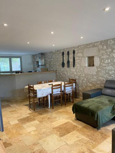 une salle à manger avec une table et des chaises et une cuisine dans l'établissement Gîte la Grande Font, à Saint-Capraise-dʼEymet