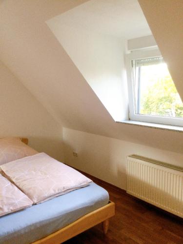 een slaapkamer met een bed en een raam bij Wohnung mit Stil in Troisdorf