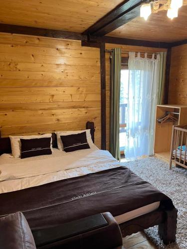 a bedroom with a bed with a wooden wall at Котедж Chalet Adriana in Bukovel