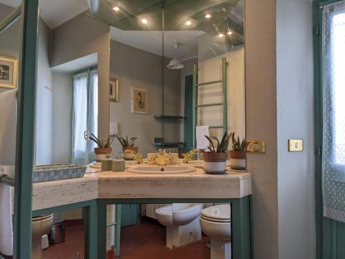 ein Badezimmer mit 2 WCs und einem großen Spiegel in der Unterkunft B&B Il Poggiolo in Stresa