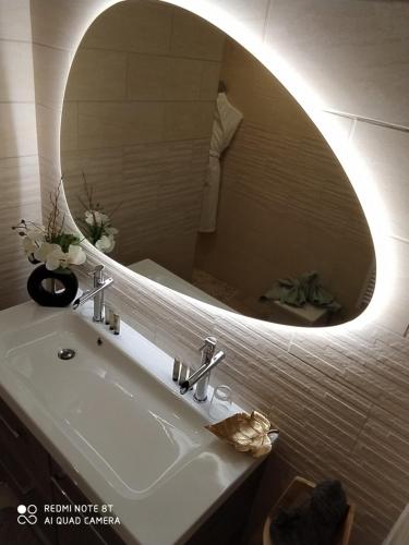 y baño con lavabo y espejo. en O spa de Caudry, en Caudry