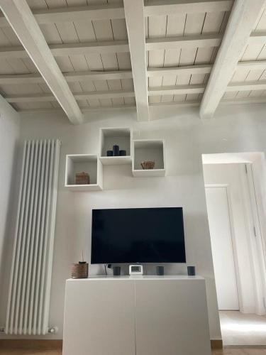 a living room with a flat screen tv on a white wall at Casina Cesena in Cesena