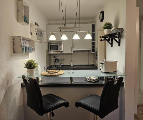 a kitchen with a counter with two chairs and a table at City Appartement 2 Hannover Altstadt in Hannover