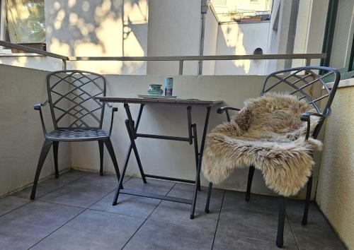 a table and two chairs with a furry pillow on it at City Appartement 2 Hannover Altstadt in Hannover