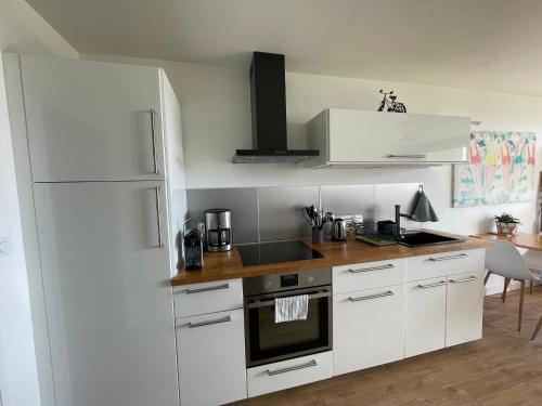 a kitchen with white cabinets and a white refrigerator at Appartement Belles Vacances in Quiberon