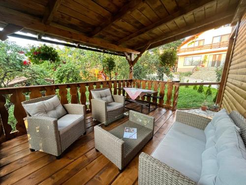een patio met stoelen en een bank op een houten terras bij Sunset Expanse in Turda