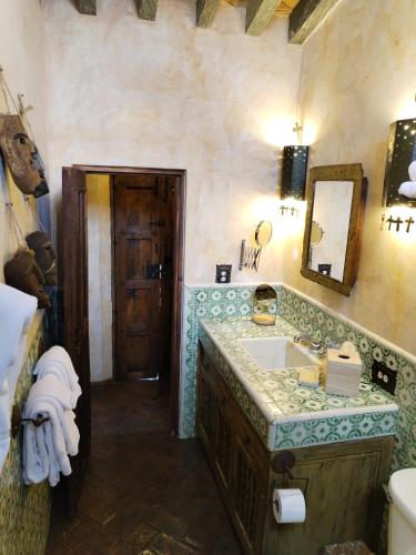 un baño con lavabo y espejo en Hacienda Las Amantes, en San Miguel de Allende
