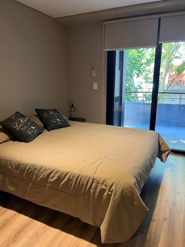 een slaapkamer met een groot bed en een groot raam bij Hermoso monoambiente con muy buena ubicación. in Rosario