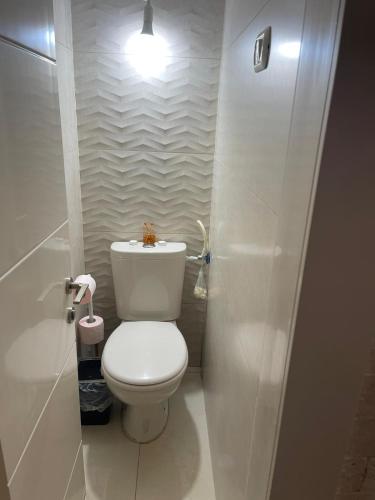 a white bathroom with a toilet and a light at Estrela Mares Haifa apartment in Haifa