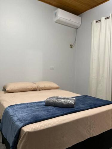 a bed with a blue blanket and a pillow on it at Casa Iguaçu in Foz do Iguaçu