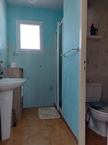 ein Bad mit einem Waschbecken, einem WC und einem Fenster in der Unterkunft MaMaMé in Les Sables-dʼOlonne