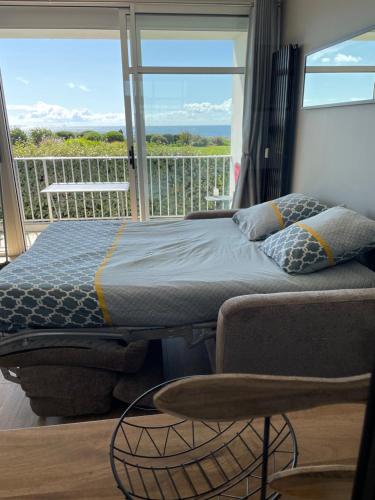 a bedroom with a bed and a balcony with a view at Appartement Belles Vacances in Quiberon
