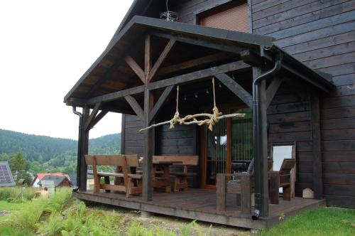 a cabin with a wooden porch with benches on it at Cisna Chata - Bieszczady in Cisna