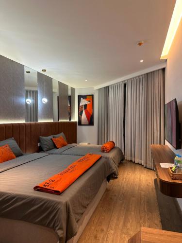 a bedroom with two beds with an orange blanket on it at S0410 Apec Mui Ne in Ấp Thiẹn Ái