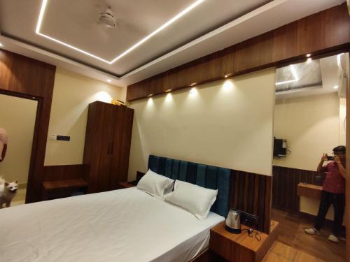a person taking a picture of a bed in a room at HOTEL B S HEIGHTS in Deoghar